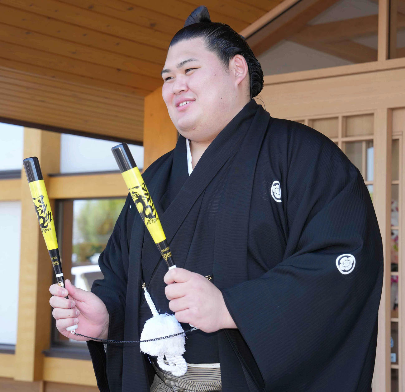 横綱昇進伝達式を終え関係者から渡された阪神グッズを手にする新横綱大の里（撮影・小沢裕）