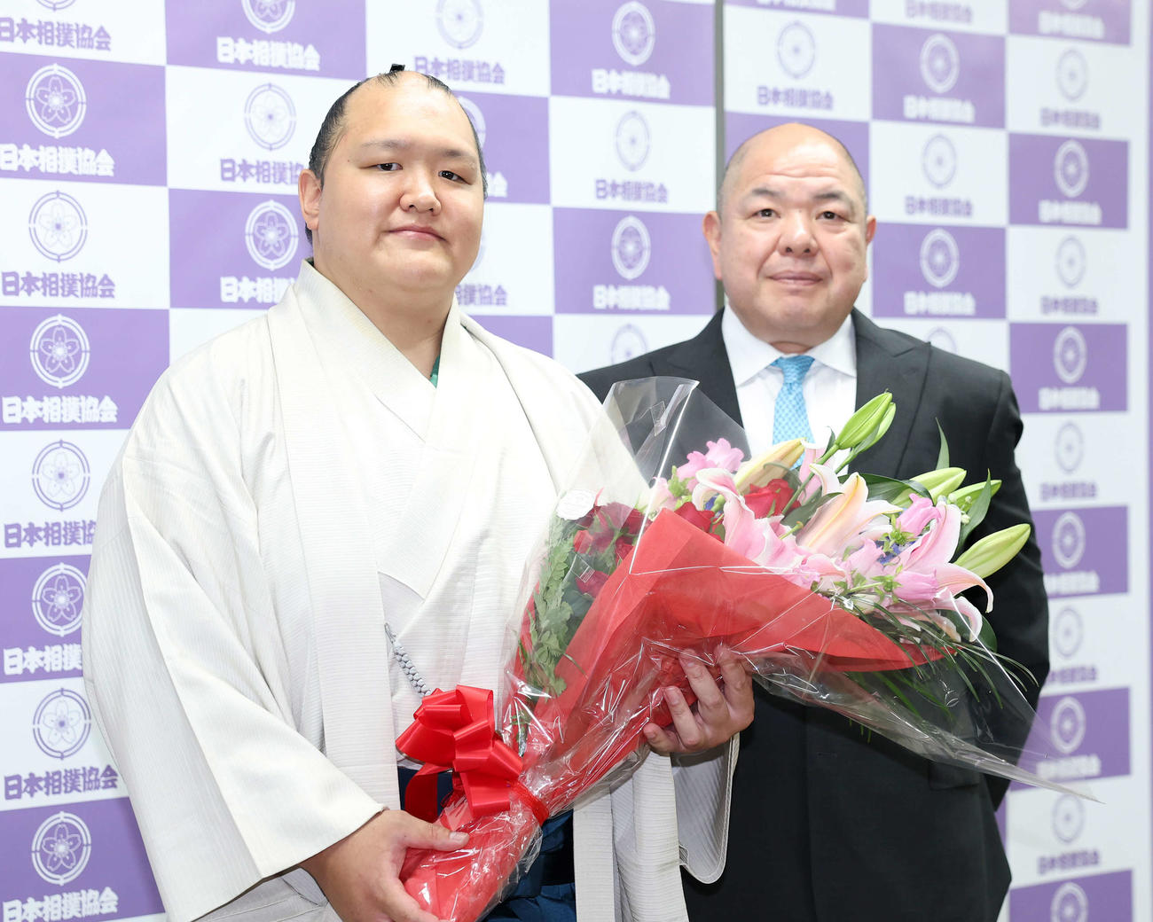 2025年5月15日、花束を手に写真に納まる北勝富士（左）と師匠の八角理事長