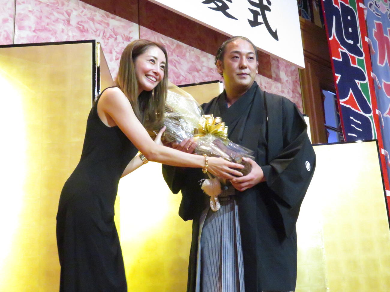 まげと別れを告げた直後、タレントのと熊切あさ美（左）から花束を受け取った元旭大星の大串氏