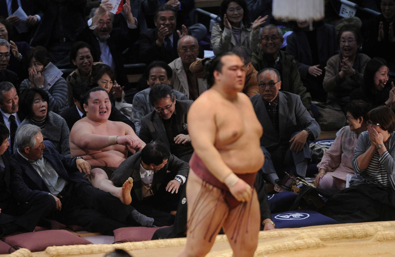 10年11月、稀勢の里（手前）に敗れ連勝が63でストップした白鵬はたまり席の中で尻もちをついたまま苦笑い