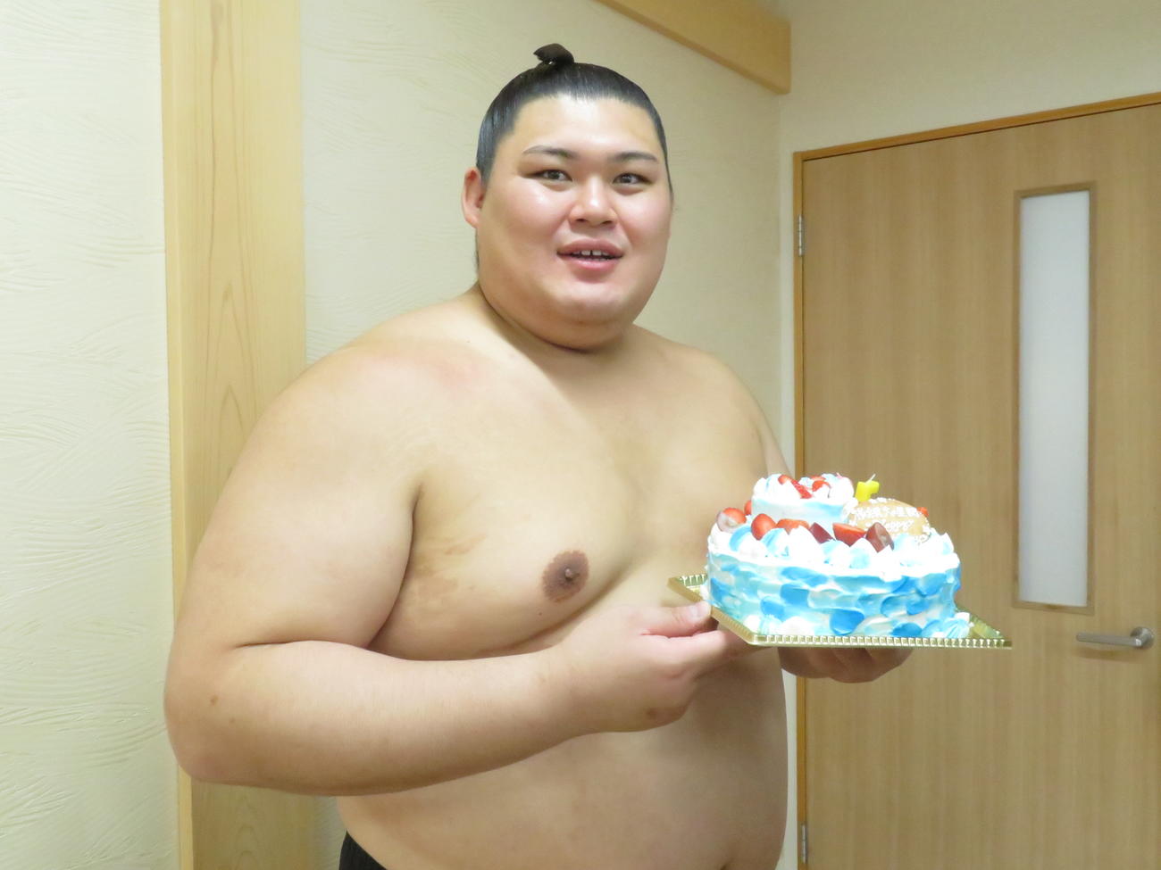 25歳の誕生日に贈られたケーキを手に、笑顔を見せる大の里