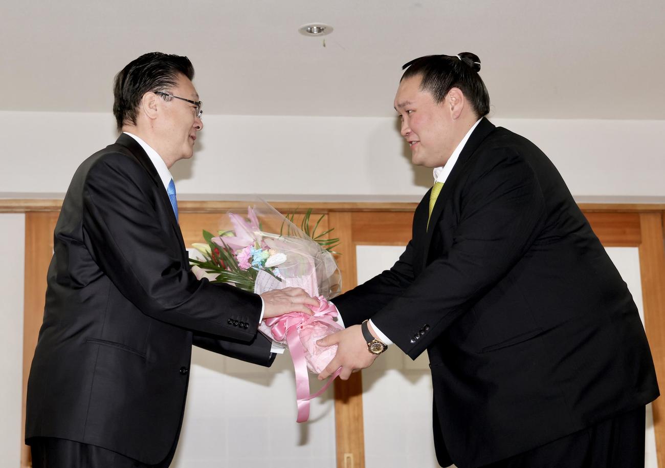 宮城野親方（左）に花束を渡す伊勢ケ浜親方（撮影・河田真司）