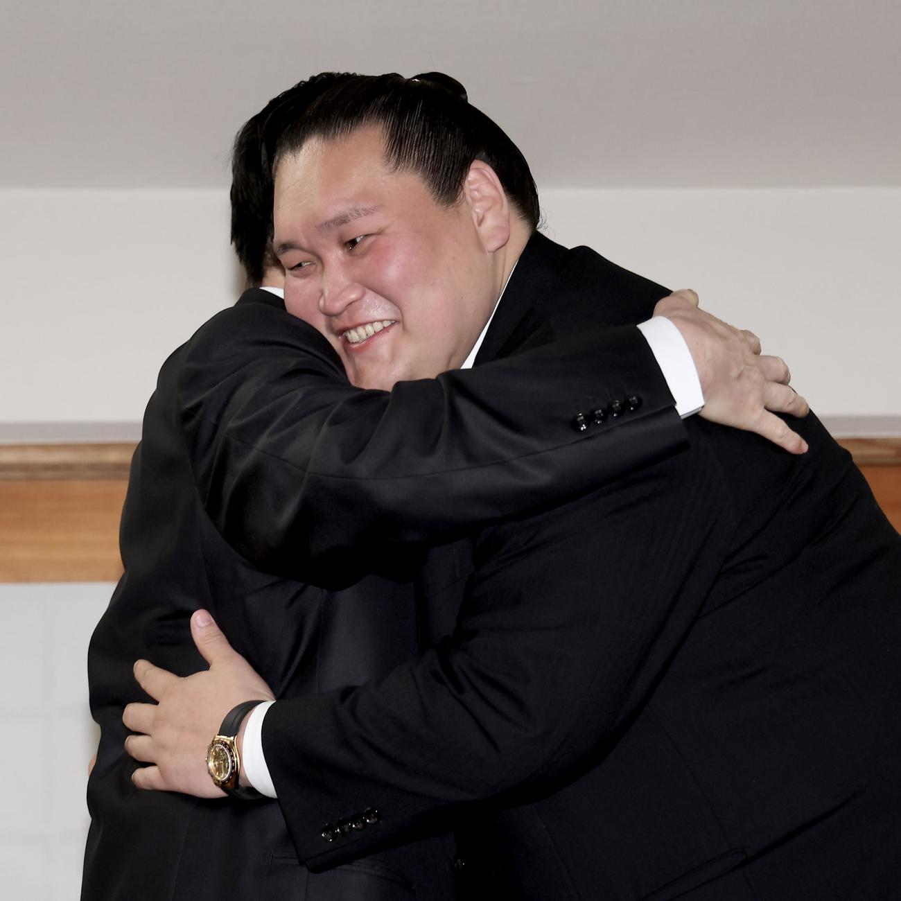 会見を終え、宮城野親方（左）を笑顔で抱きしめる伊勢ケ浜親方（撮影・河田真司）