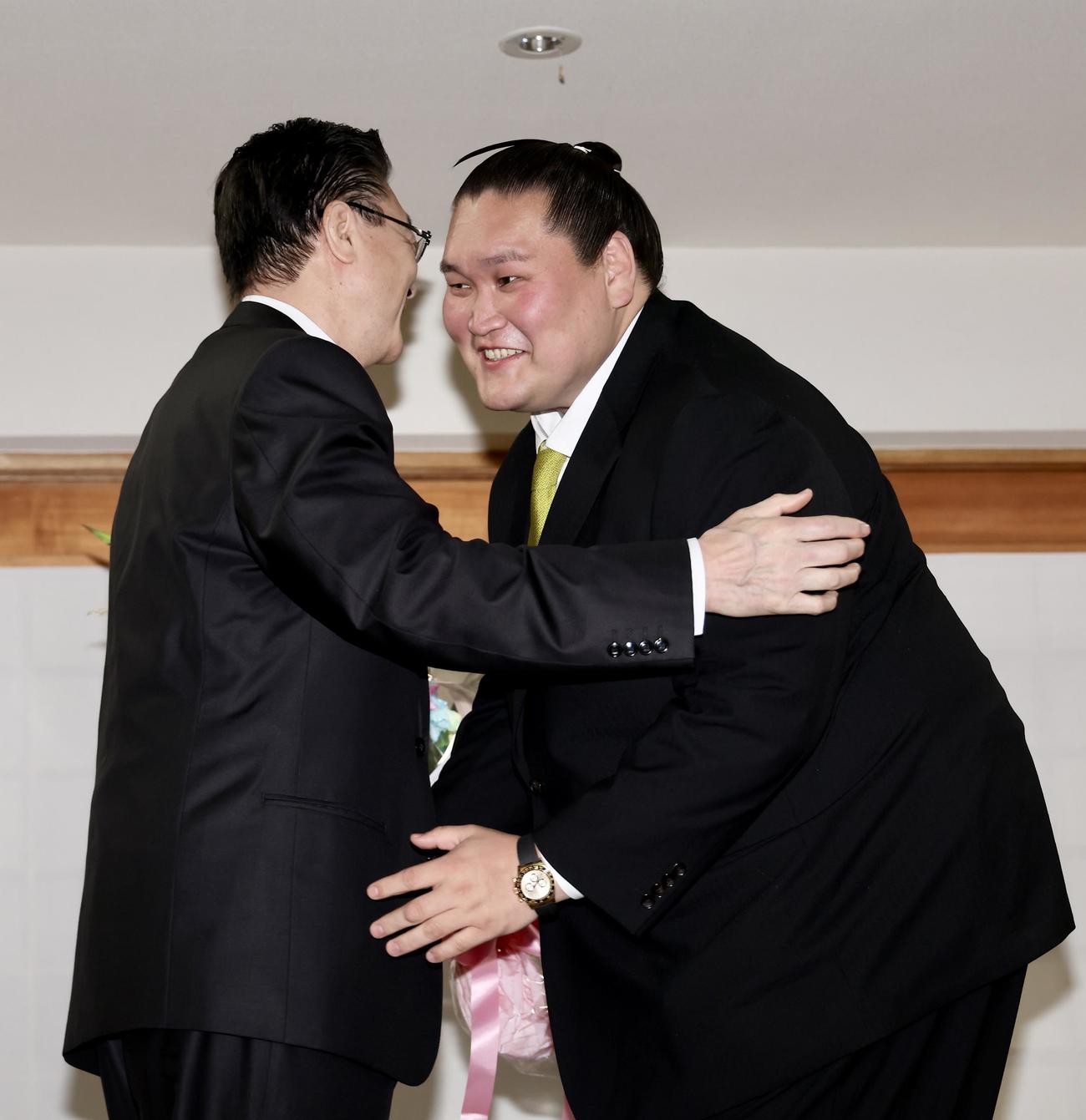 会見を終え、宮城野親方（左）を笑顔で抱きしめる伊勢ケ浜親方（撮影・河田真司）