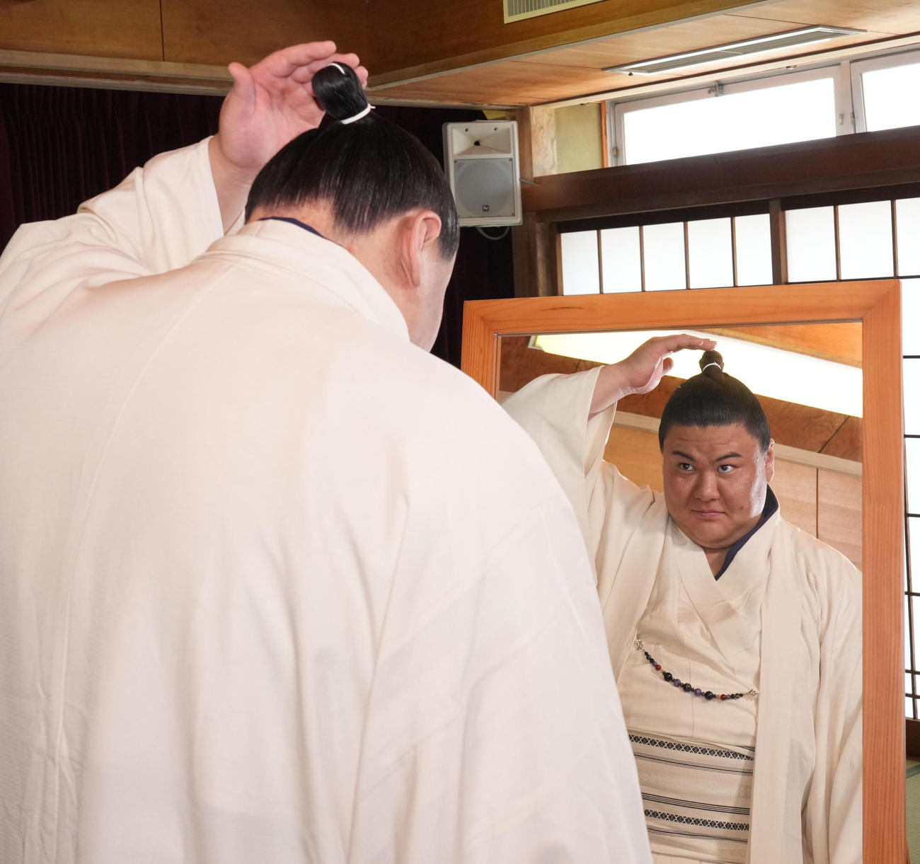 会見を終え自身の髷姿を鏡で見る草野（撮影・森本幸一）