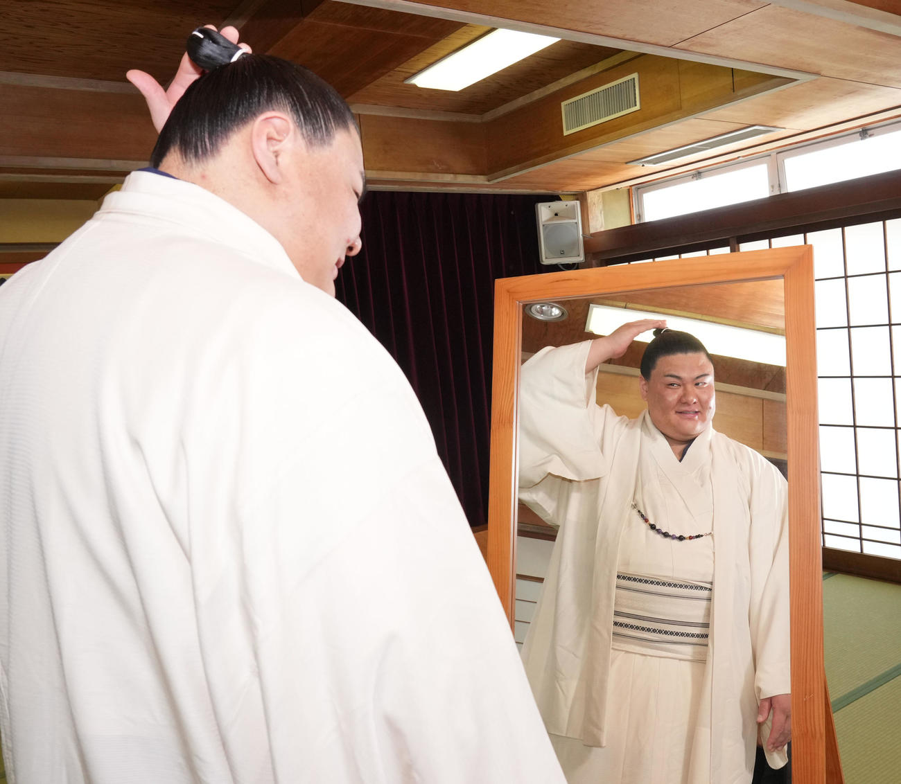 会見を終え自身の髷姿を鏡で見る草野（撮影・森本幸一）