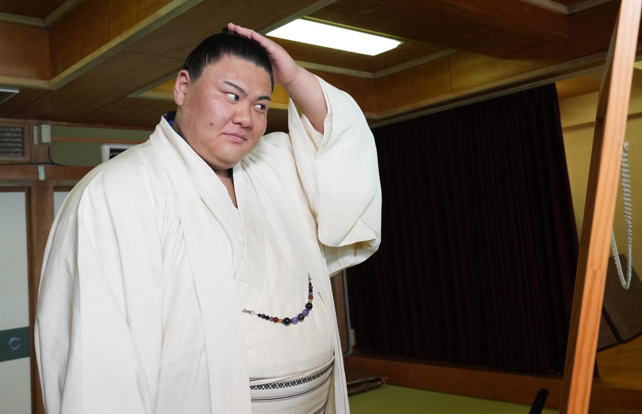 会見を終え自身の髷姿を鏡で見る草野（撮影・森本幸一）