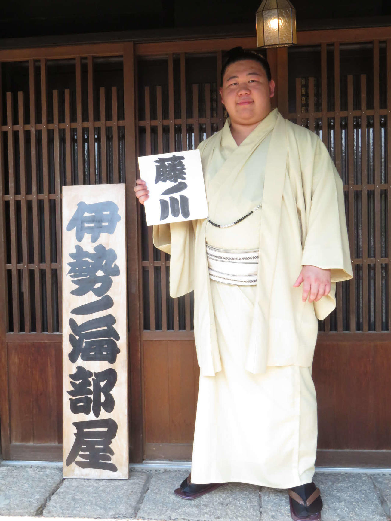 若碇改め藤ノ川は新入幕会見後、しこ名が書かれた色紙を手に部屋の看板の隣で記念撮影に納まった