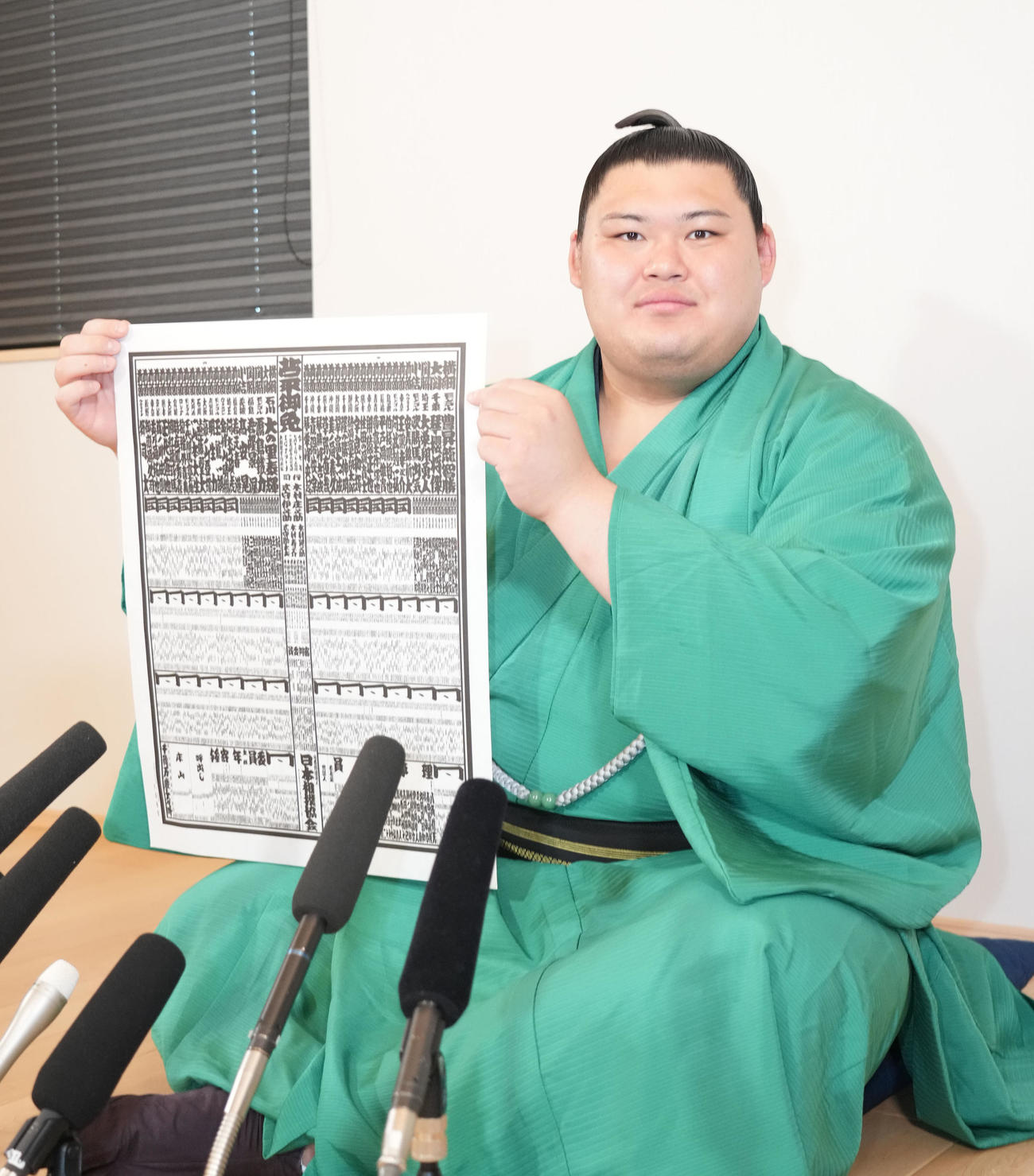 番付表を手に会見の冒頭、撮影に応じる横綱大の里（撮影・森本幸一）