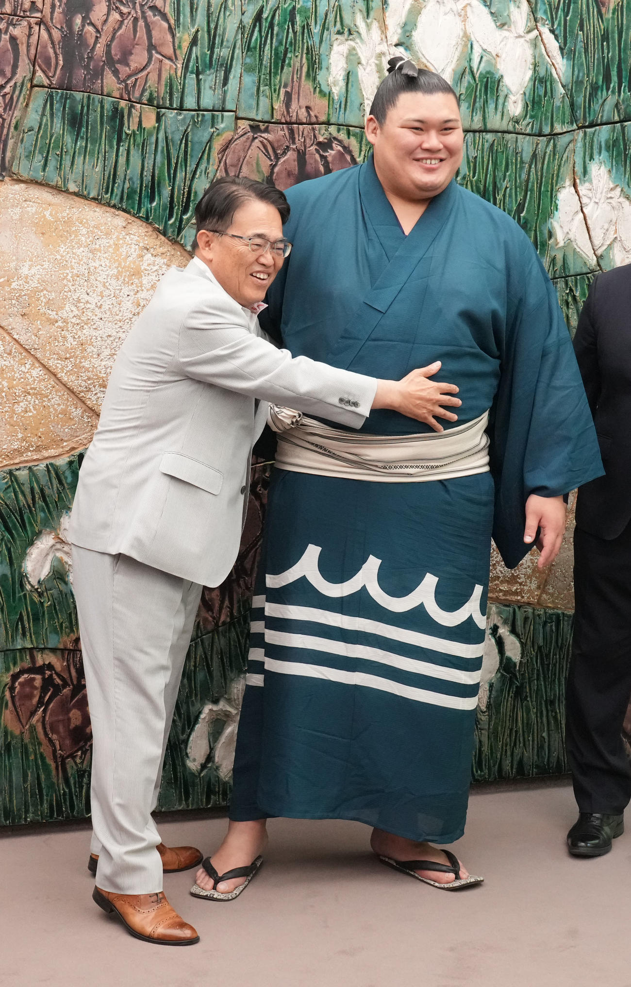 大村秀章愛知県知事（左）は表敬訪問に訪れた大の里の体に手を伸ばす（撮影・森本幸一）