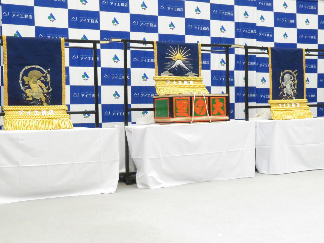 大の里に贈呈された三つぞろえの化粧まわし。左から太刀持ち用には風神、大の里用には富士山と朝日、露払い用には雷神がデザインされた