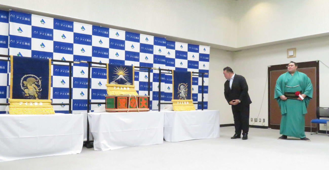 三つぞろえの化粧まわしの贈呈式に臨んだ大の里（右）。左は師匠の二所ノ関親方