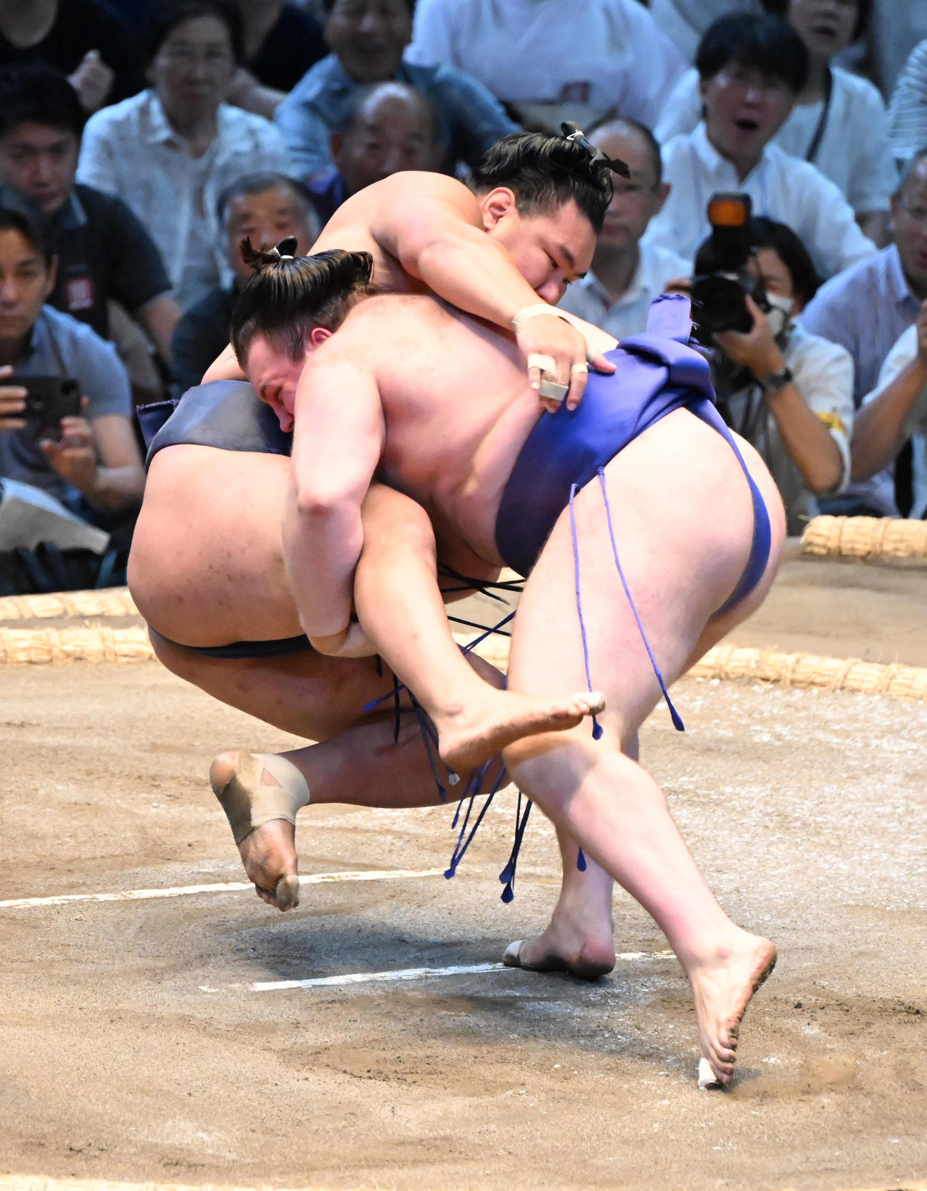 豊昇龍（奥）を渡し込みで破る安青錦（撮影・和賀正仁）