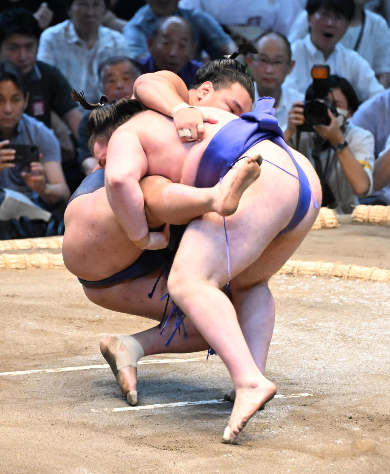豊昇龍（奥）を渡し込みで破る安青錦（撮影・和賀正仁）