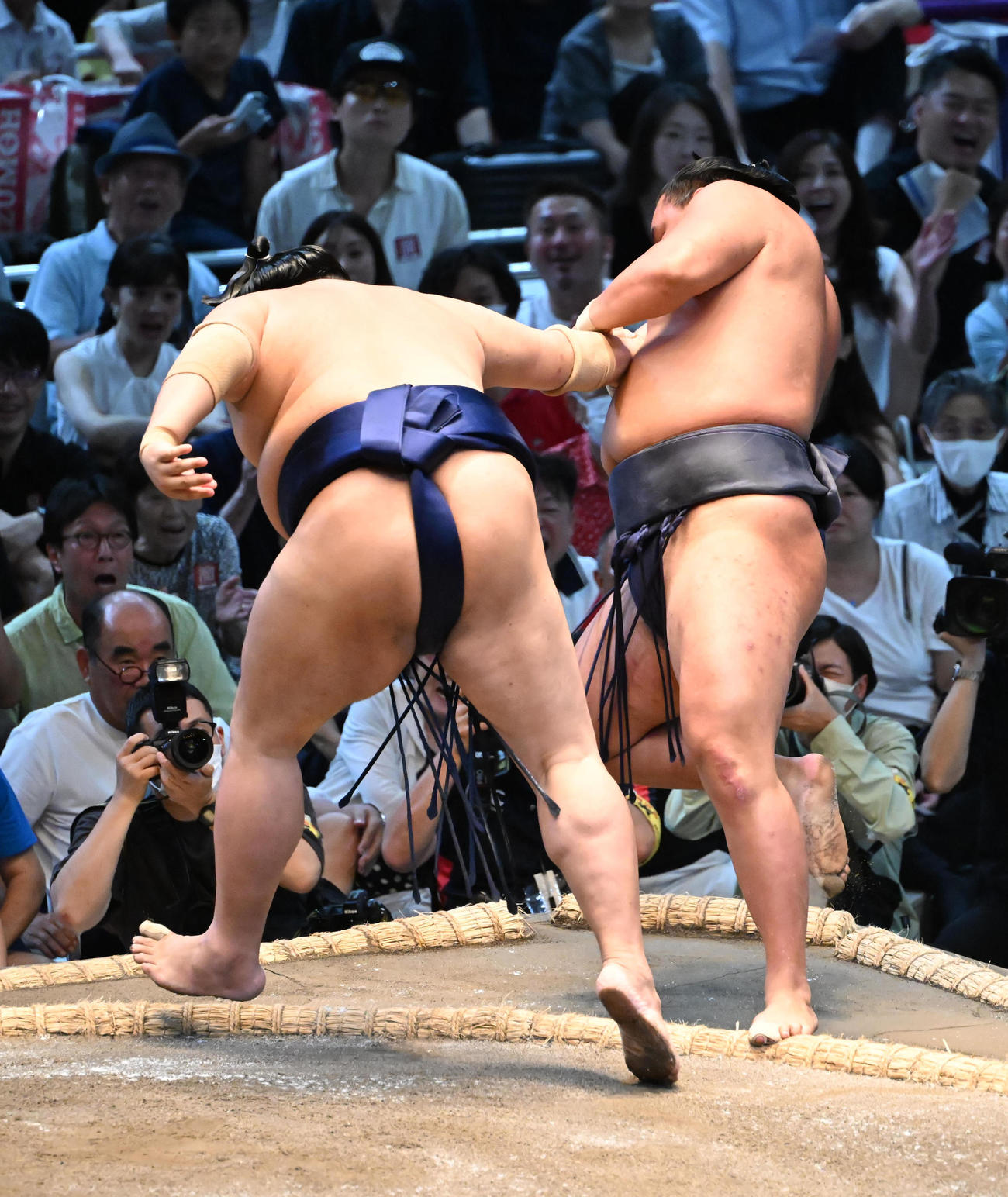 豊昇龍（奥）を押し出しで破る阿炎（撮影・和賀正仁）