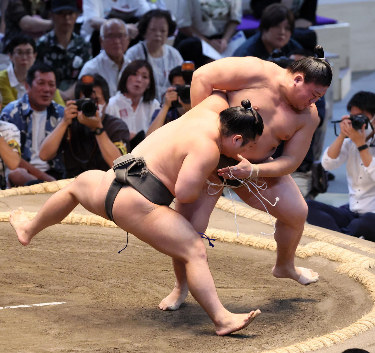石崎(左）は押し出しで西ノ龍を下す（撮影・加藤哉）