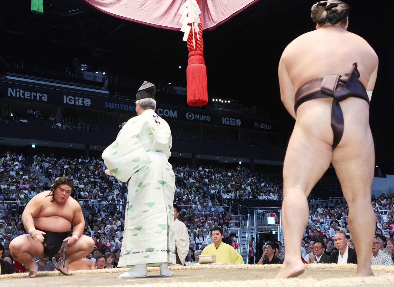 伯桜鵬は押し出しで霧島を下したがまげが乱れてざんばら髪で勝ち名乗りを受ける（撮影・西尾就之）