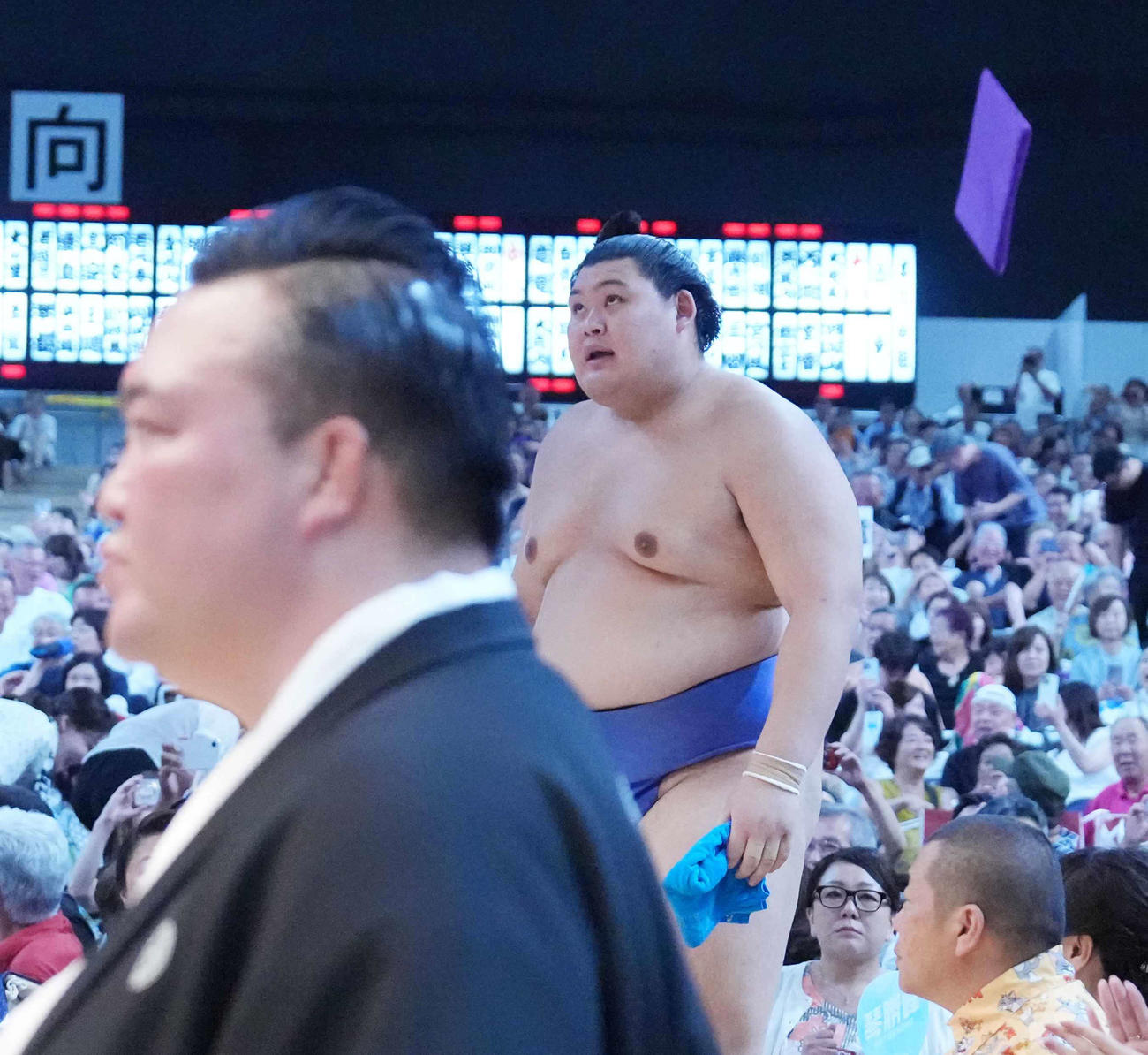 3敗目を喫した大の里は館内に座布団が舞うなか花道を引き揚げる。手前左は審判を務めた師匠の二所ノ関親方（撮影・小沢裕）