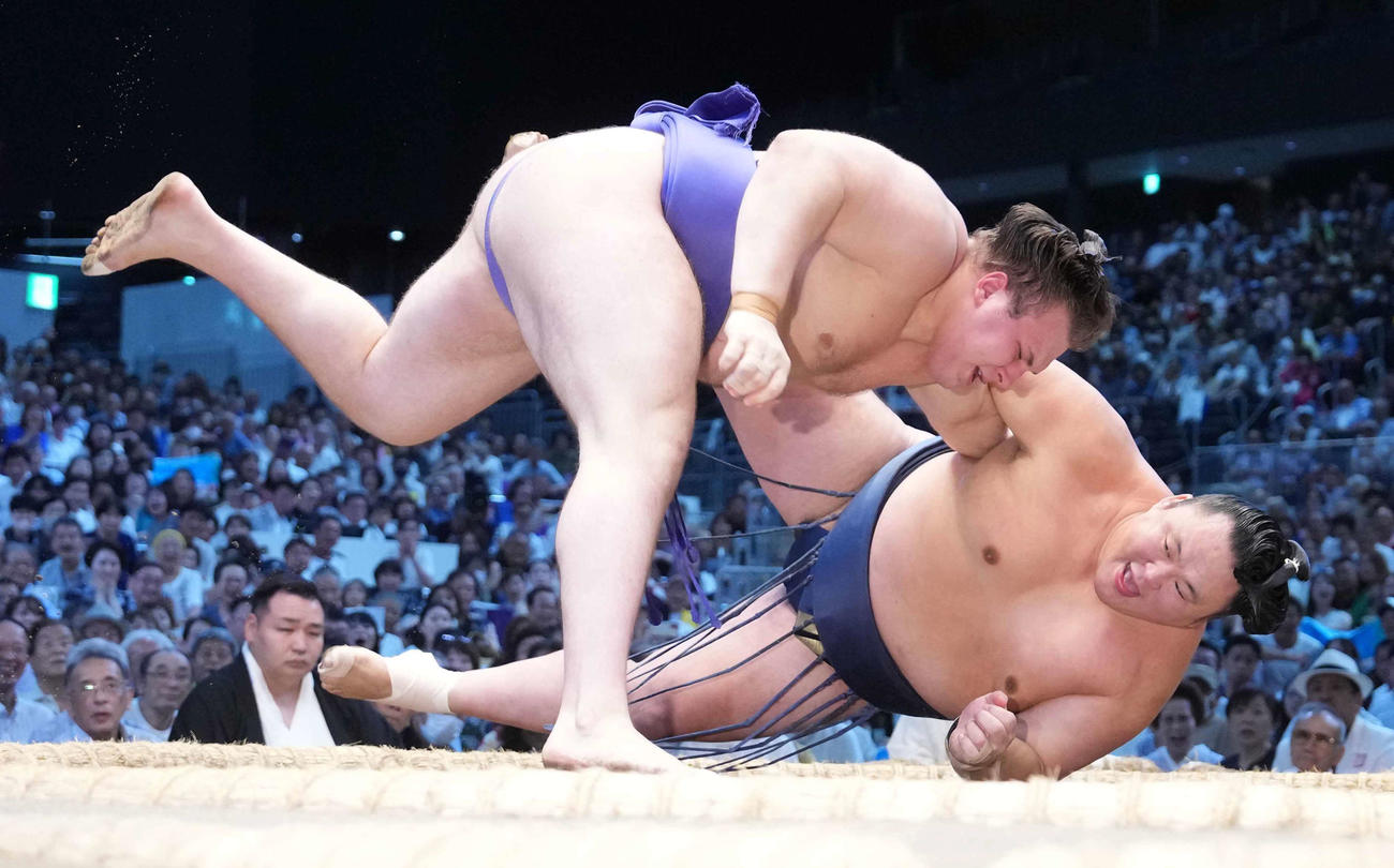 安青錦（左）は玉鷲を下手投げで下す（撮影・小沢裕）