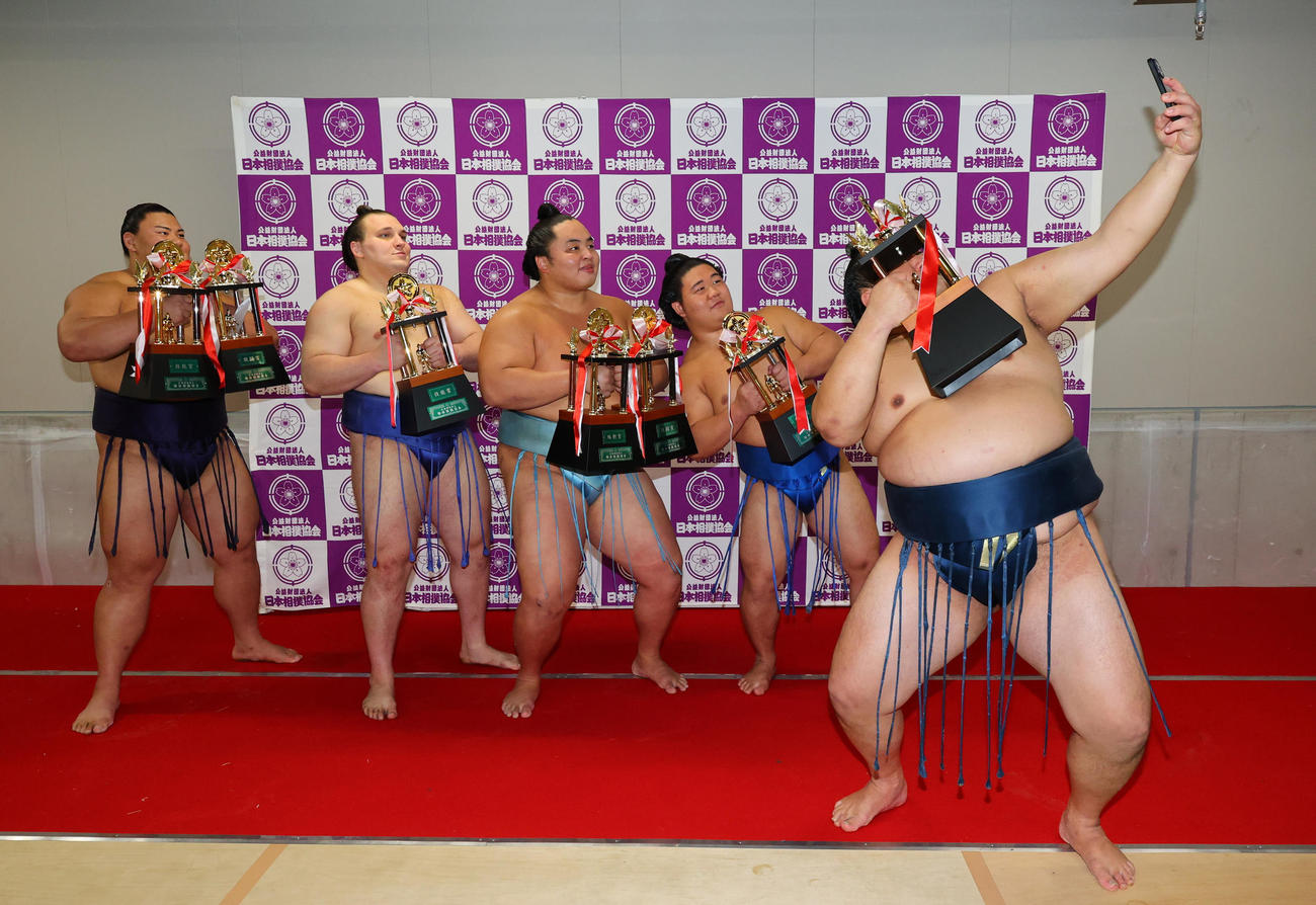 玉鷲（右端）が手にするスマホで記念撮影する、左から草野、安青錦、琴勝峰、藤ノ川（代表撮影）