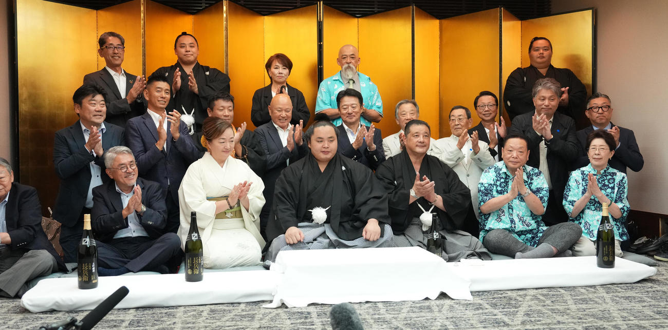 師匠の佐渡ヶ嶽親方（前例右から3人目）、後列左から2人目の琴栄峰、母カツ江さん、父学さん、大関琴桜（右端）らの祝福を受ける琴勝峰（撮影・小沢裕）