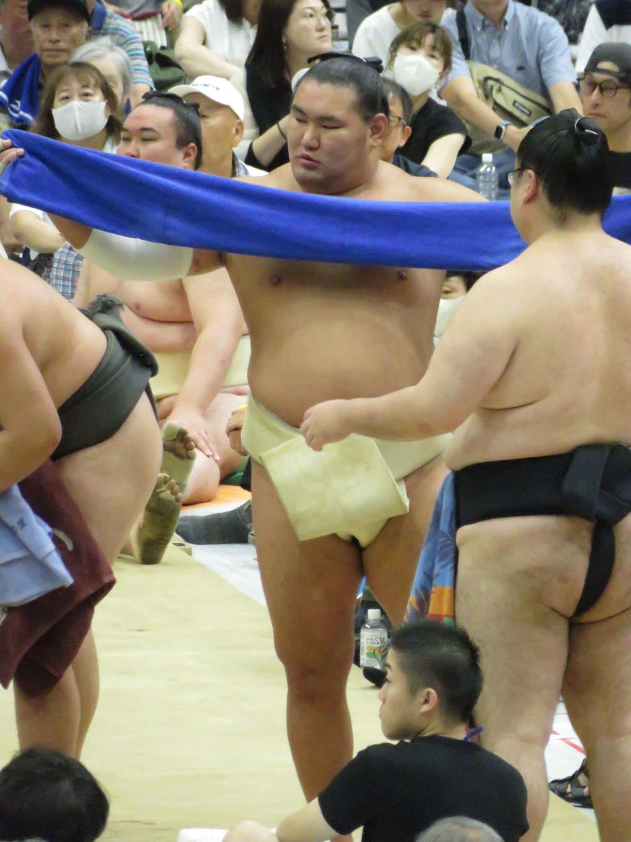 盛岡市巡業の朝稽古で土俵に上がる前に汗をふくため、タオルを伸ばしてから畳む豊昇龍