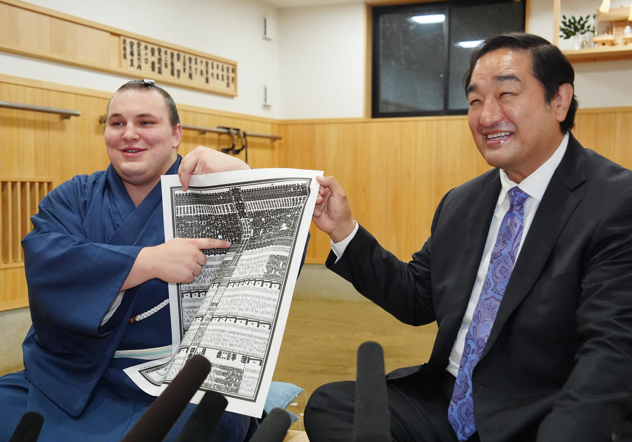 番付表を手に笑顔を見せる安青錦（左）。右は安治川親方（撮影・江口和貴）