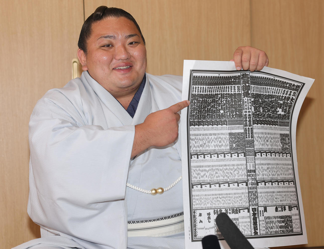 新入幕を果たし番付表を手に笑顔をみせる日翔志（撮影・野上伸悟）