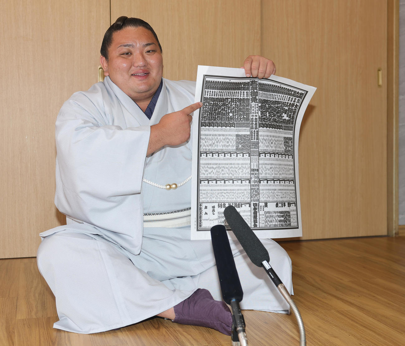 新入幕を果たし番付表を手に笑顔をみせる日翔志（撮影・野上伸悟）