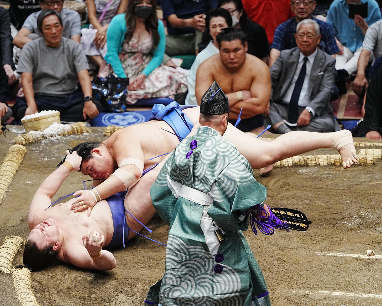 大の里は安青錦（左）を寄り倒しで下す。後方は土俵下控えの豊昇龍（撮影・小沢裕）
