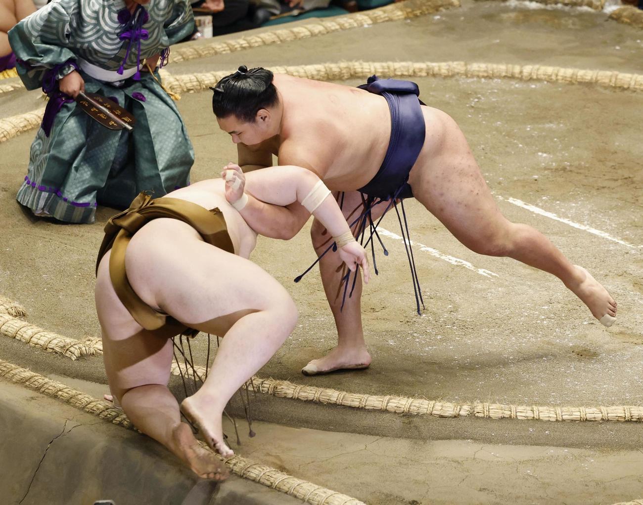 豊昇龍（右）が下手投げで王鵬を下す（共同）