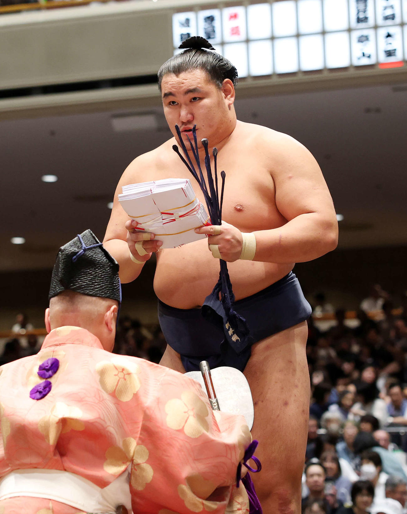 懸賞金の束を手に土俵を引き揚げる豊昇龍（撮影・鈴木正人）