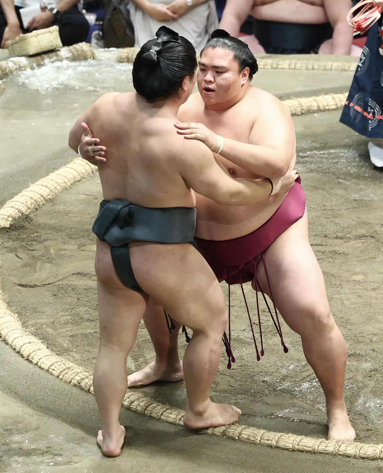朝紅龍（左）を寄り切りで破る御嶽海（撮影・河田真司）