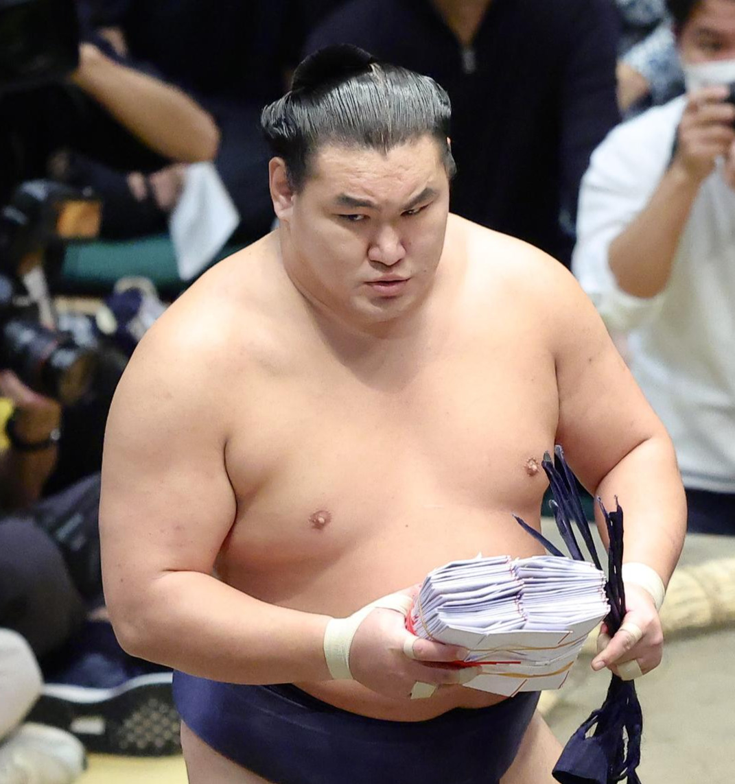 若隆景をはたき込みで破り、懸賞金の束を手に土俵から引き揚げる豊昇龍（撮影・河田真司）