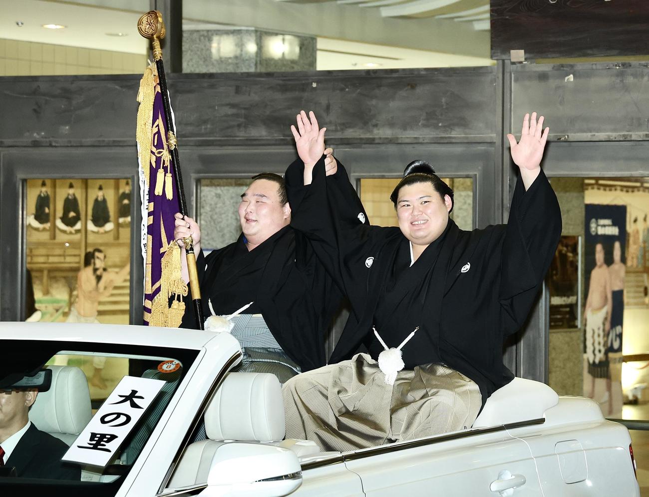 パレード車からファンの声援に応える大の里（右）と旗持ちの白熊（撮影・河田真司）