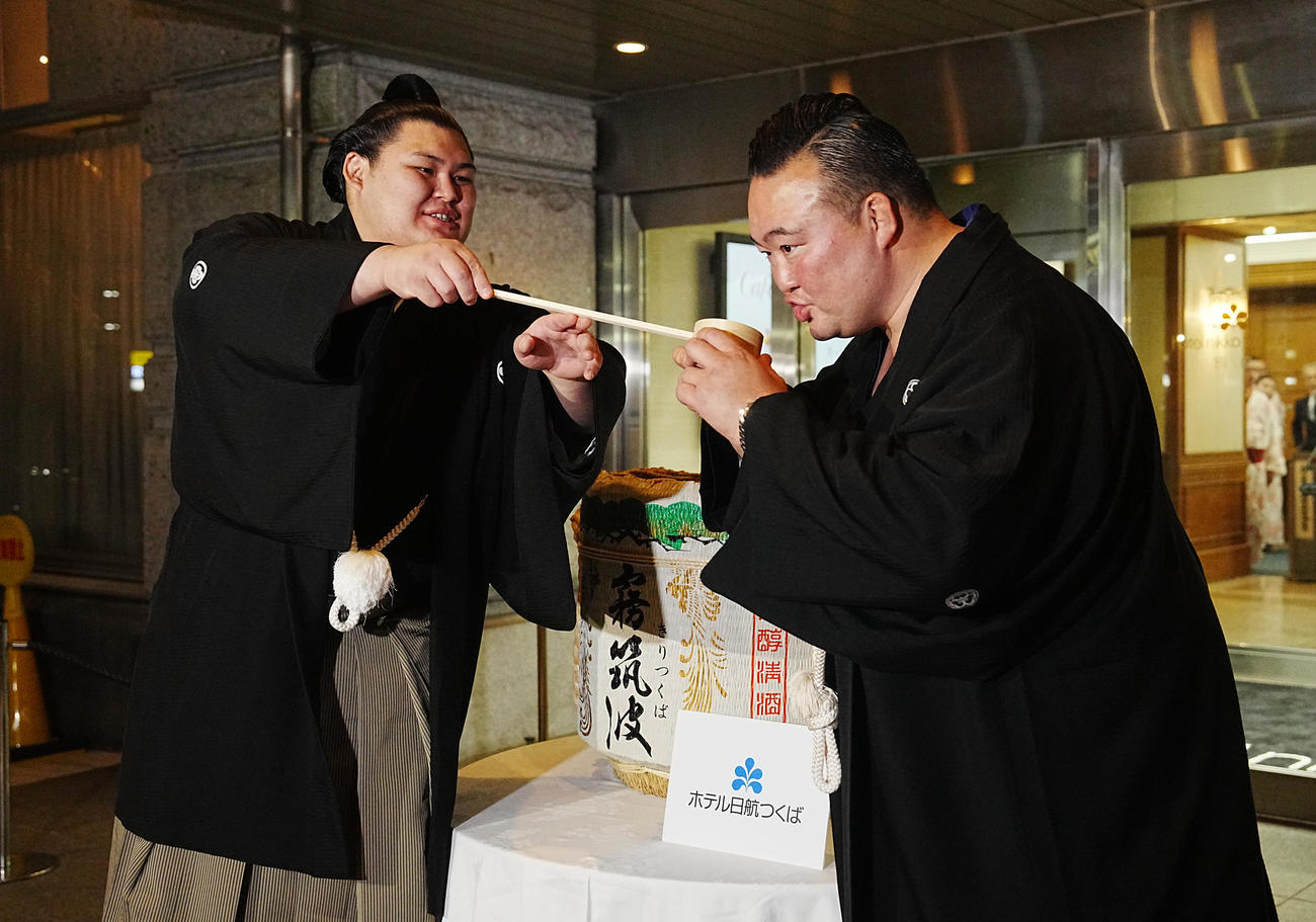 千秋楽パーティーで師匠の二所ノ関親方（右）に水を付ける大の里（撮影・小沢裕）