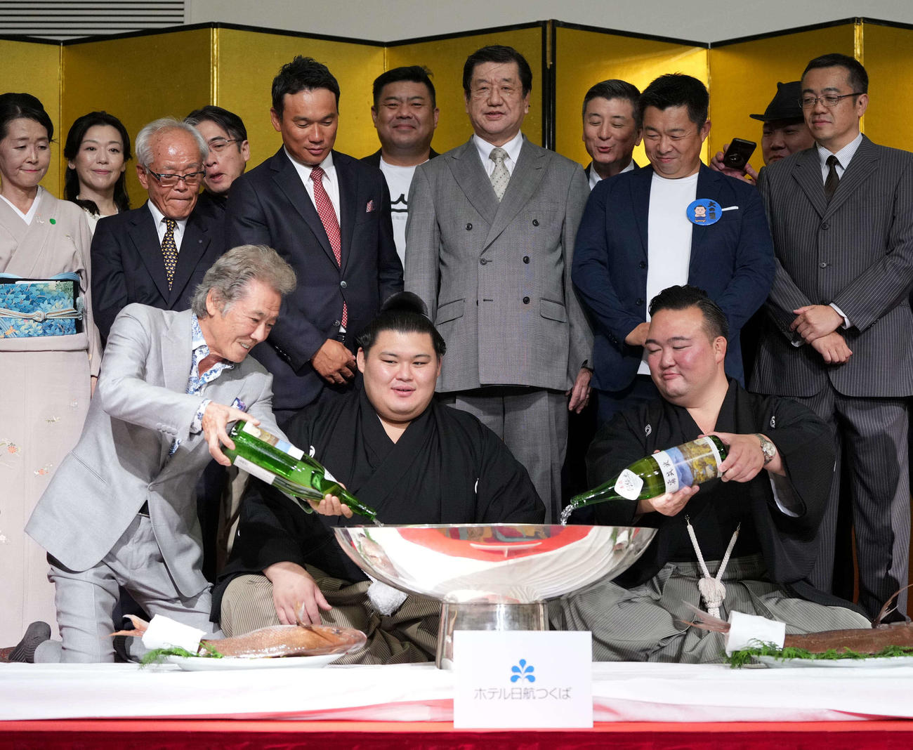 千秋楽パーティーで関係者の祝福を受けながらビールで乾杯する大の里。右は師匠の二所ノ関親方（撮影・小沢裕）