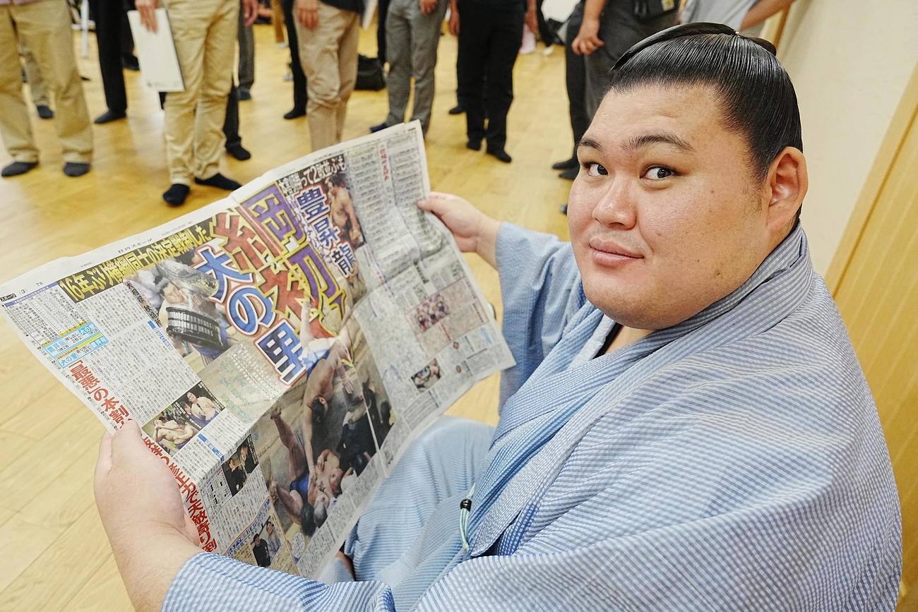 一夜明け会見を終え優勝を報じた本紙を目を通す大の里（撮影・小沢裕）