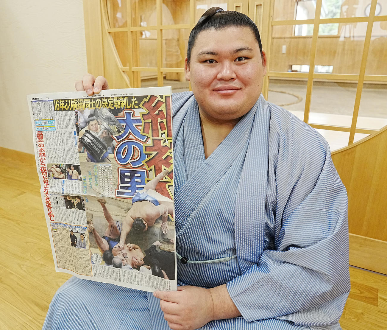 一夜明け会見を終え優勝を報じた本紙を手にする大の里（撮影・小沢裕）