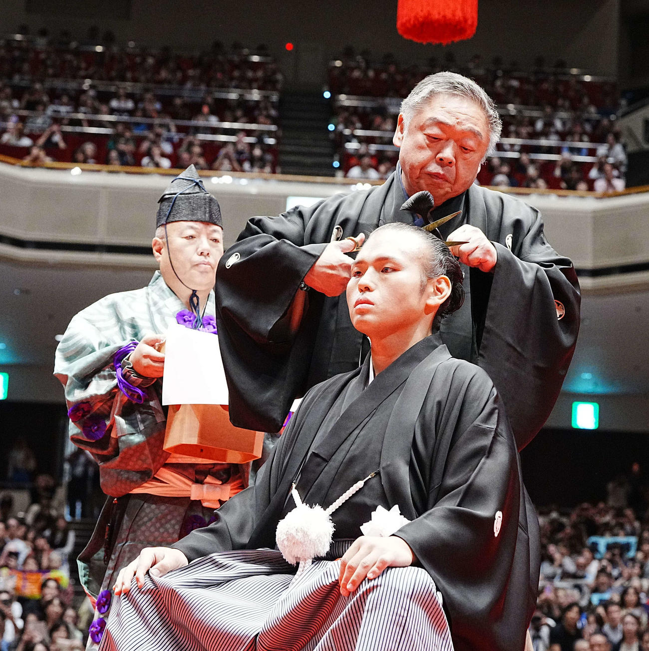 貴景勝引退湊川襲名披露大相撲で師匠の常盤山親方（後方）に止めばさみを入れてもらう湊川親方（撮影・小沢裕）