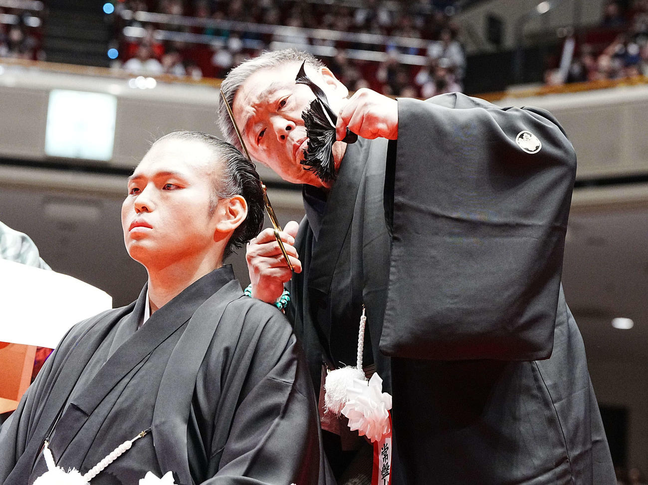 貴景勝引退湊川襲名披露大相撲で師匠の常盤山親方（後方）に止めばさみを入れてもらう湊川親方（撮影・小沢裕）