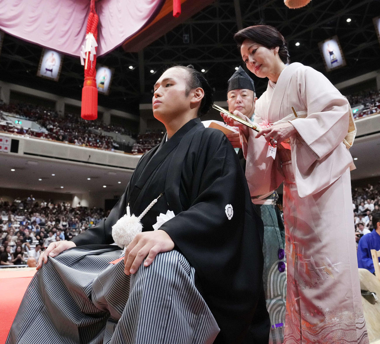 貴景勝引退湊川襲名披露大相撲で母純子さん（右）にはさみを入れてもらう湊川親方（撮影・小沢裕）