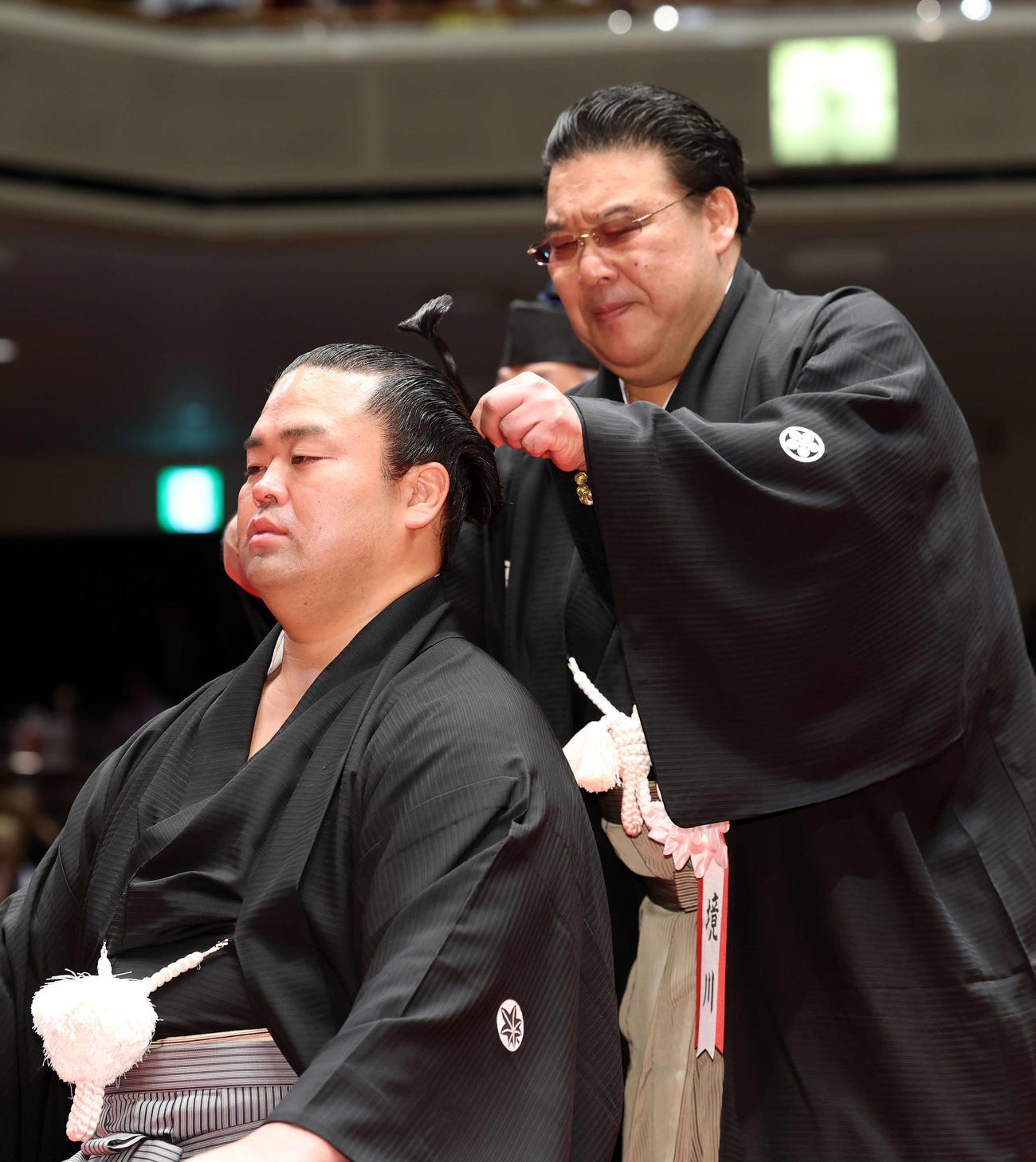 師匠の境川親方（右）に止めばさみを入れてもらう振分親方（撮影・鈴木正人）