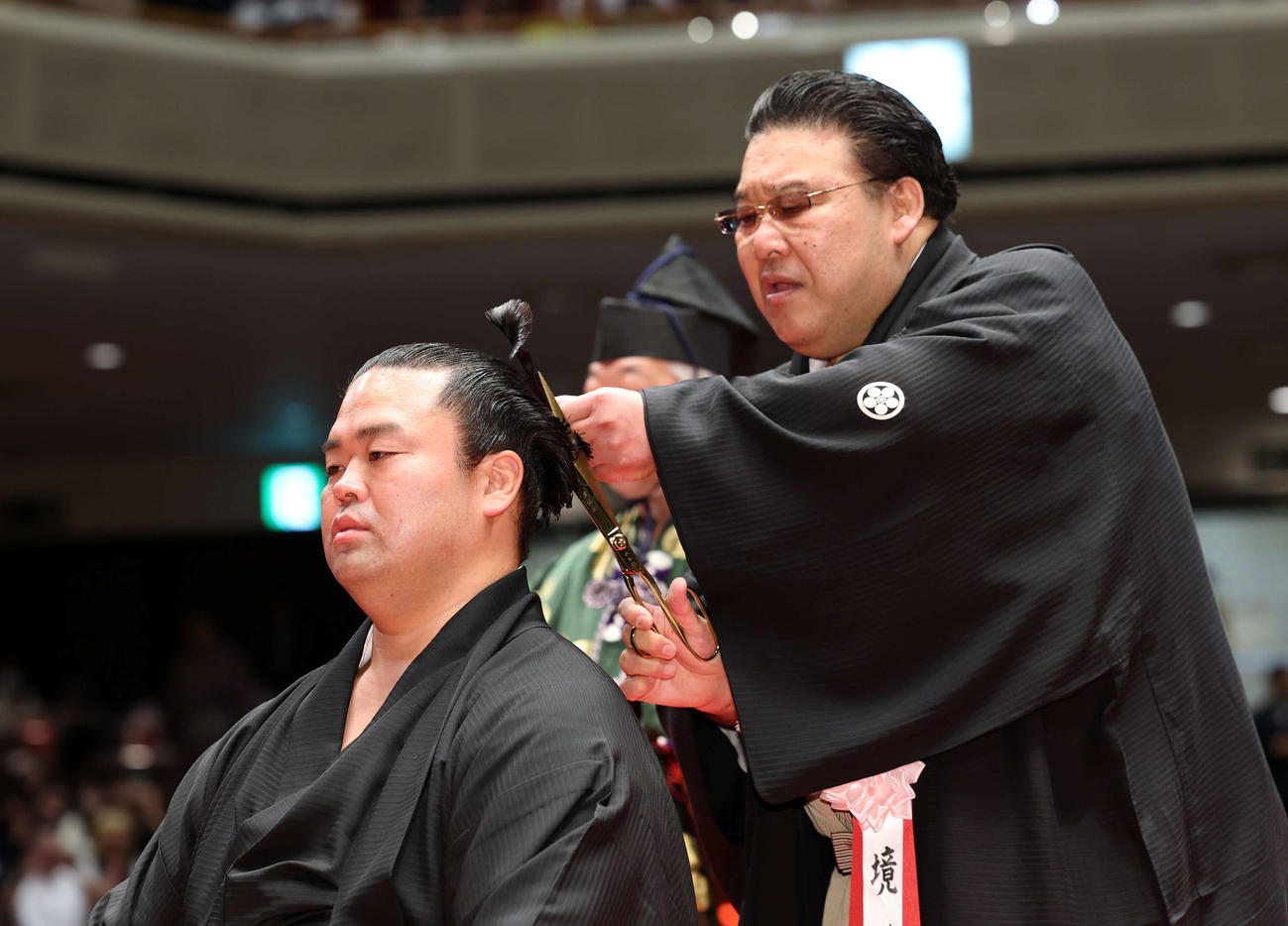 師匠の境川親方（右）に止めばさみを入れてもらう振分親方（撮影・鈴木正人）