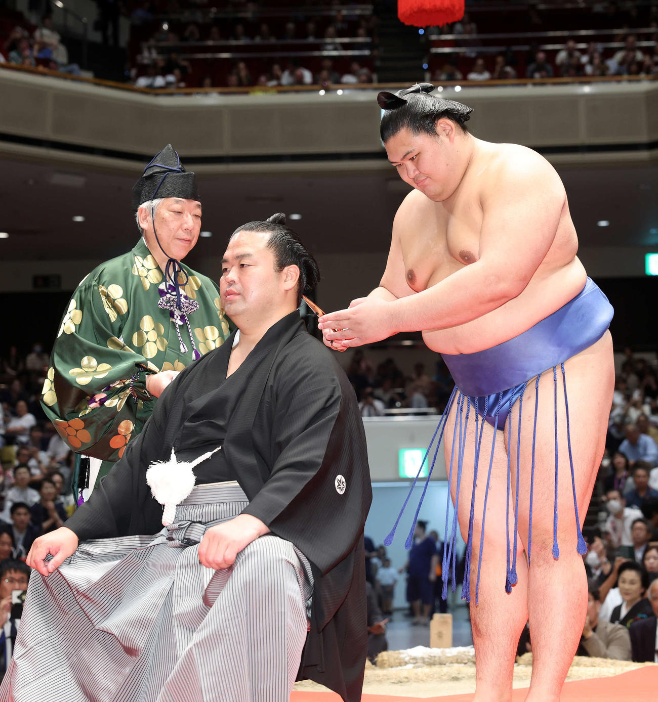 大の里（右）にはさみを入れてもらう振分親方（撮影・鈴木正人）