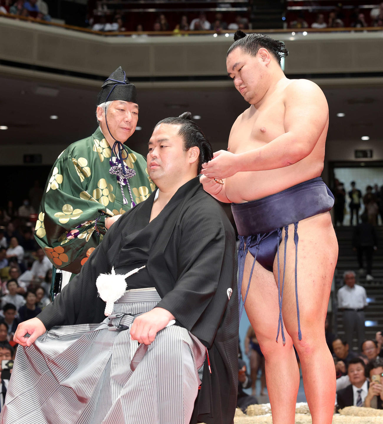 豊昇龍（右）にはさみを入れてもらう振分親方（撮影・鈴木正人）