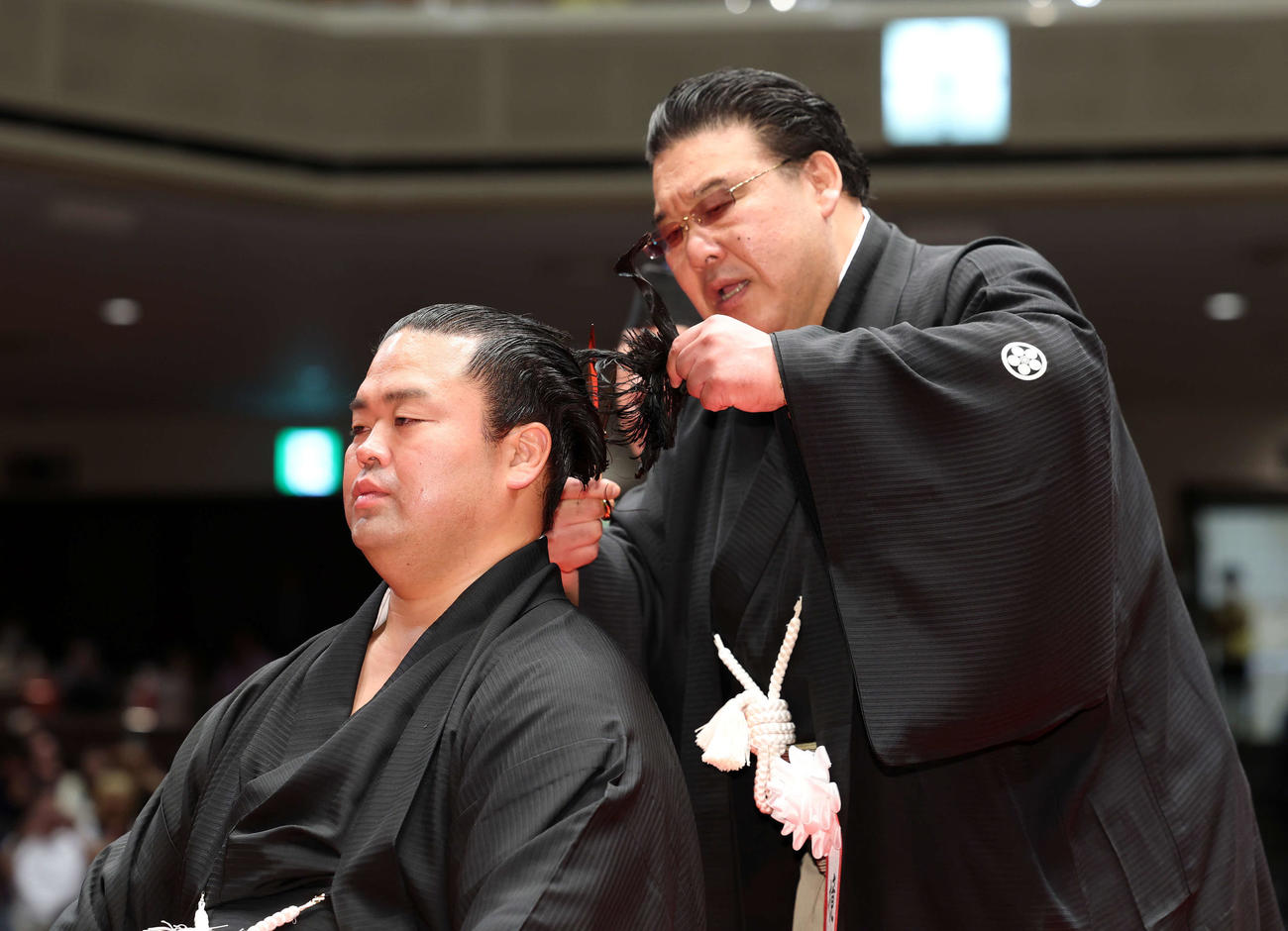 師匠の境川親方（右）に止めばさみを入れてもらう振分親方（撮影・鈴木正人）