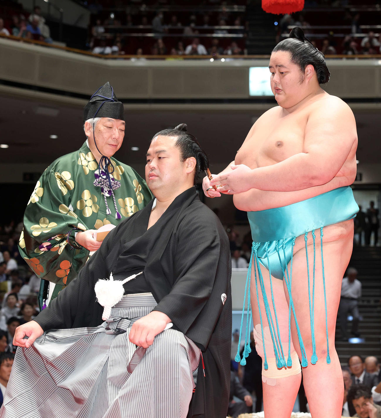琴桜（右）にはさみを入れてもらう振分親方（撮影・鈴木正人）