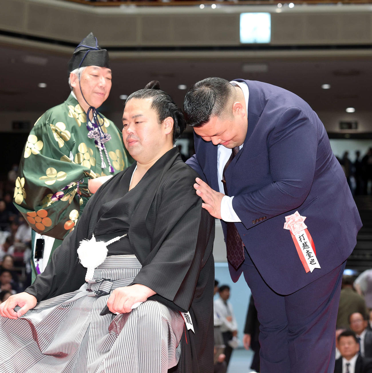 打越氏（元小結阿武咲）（右）にはさみを入れてもらう振分親方（撮影・鈴木正人）