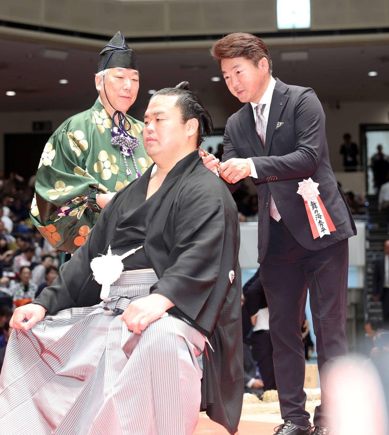 舞の海氏（右）にはさみを入れてもらう振分親方（撮影・鈴木正人）